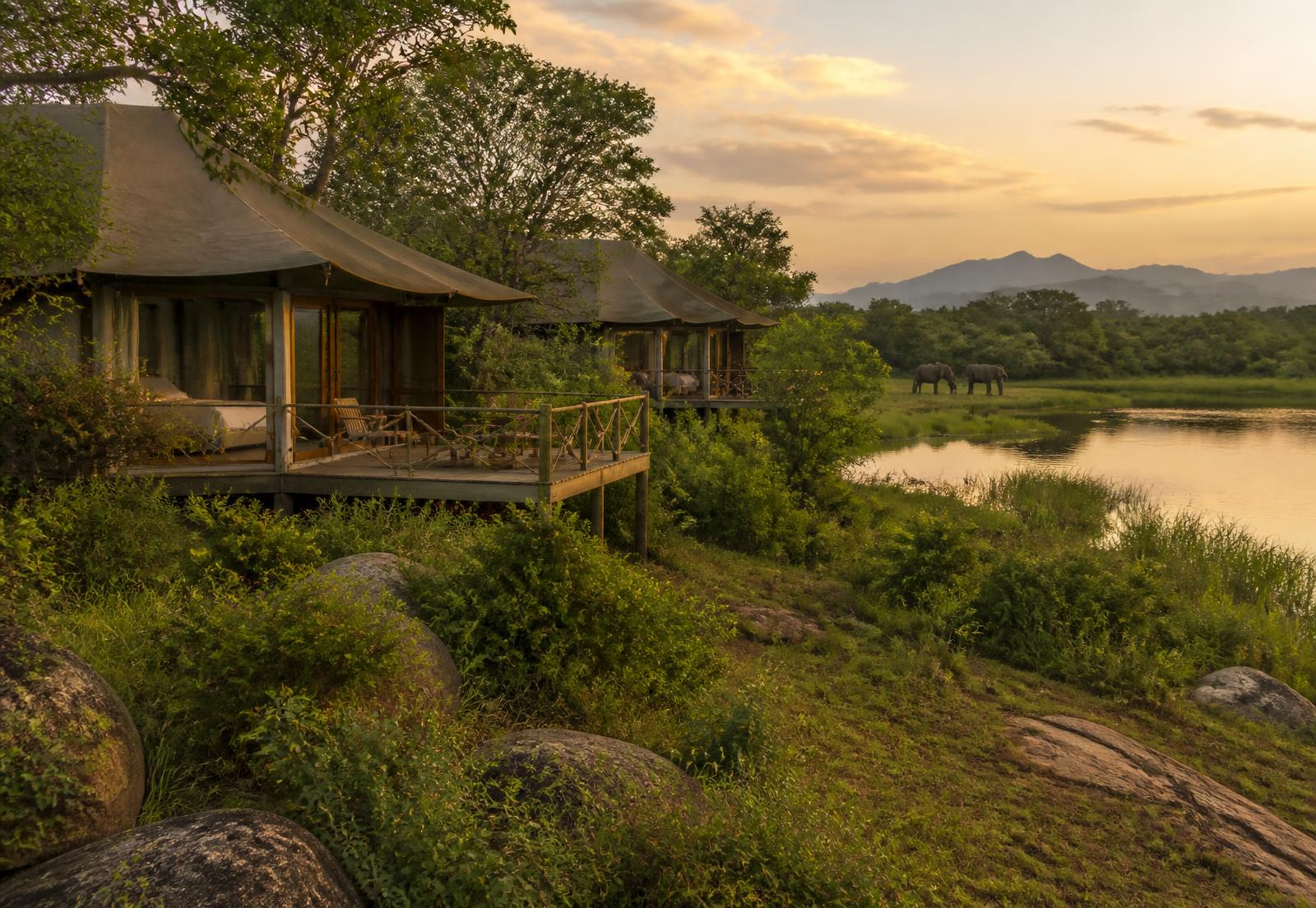 Wild Hasthi eco retreat tented villas beside a lake at golden hour in Thanamalwila